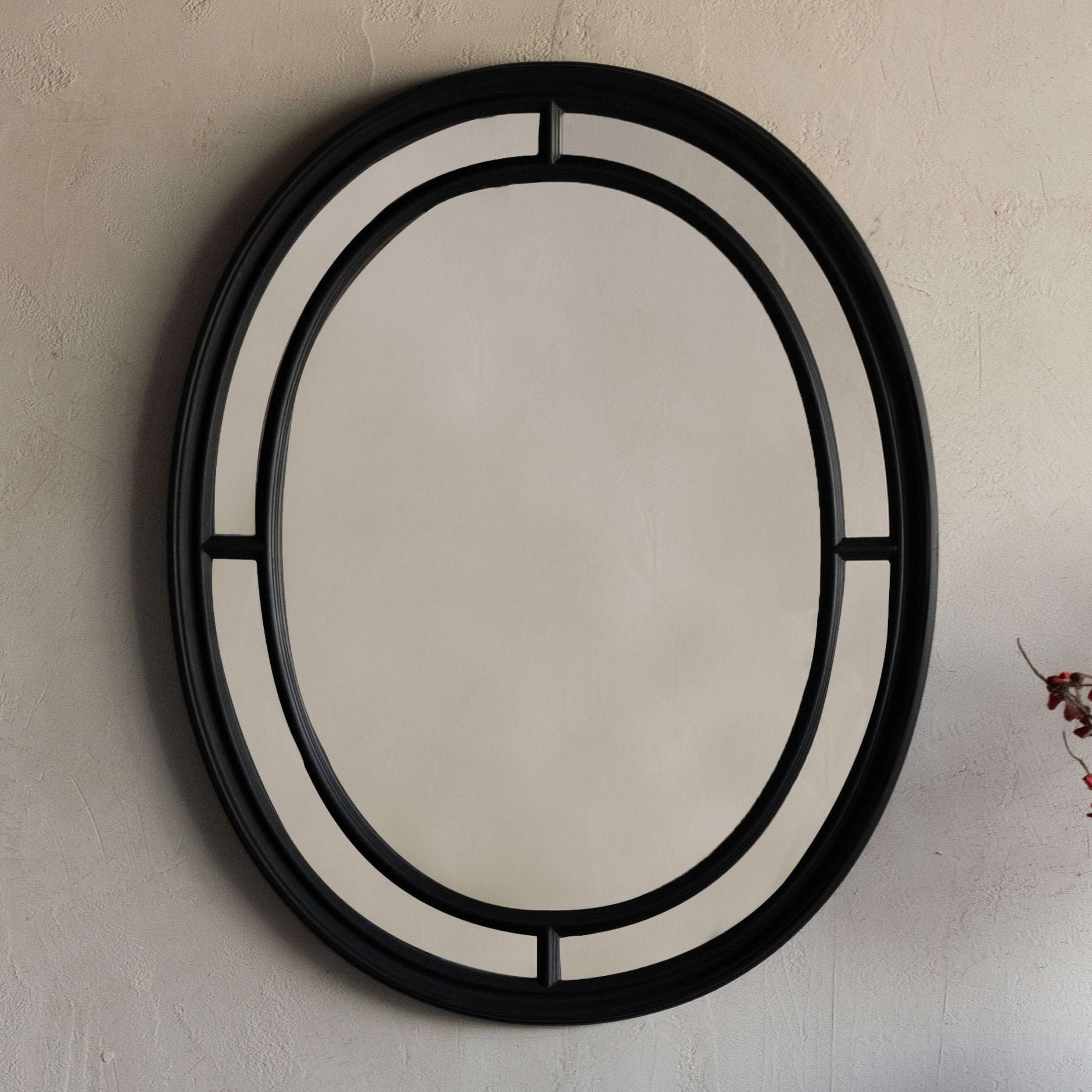 Decorative mirror with black frame on a plain wall above a dark wooden console table.