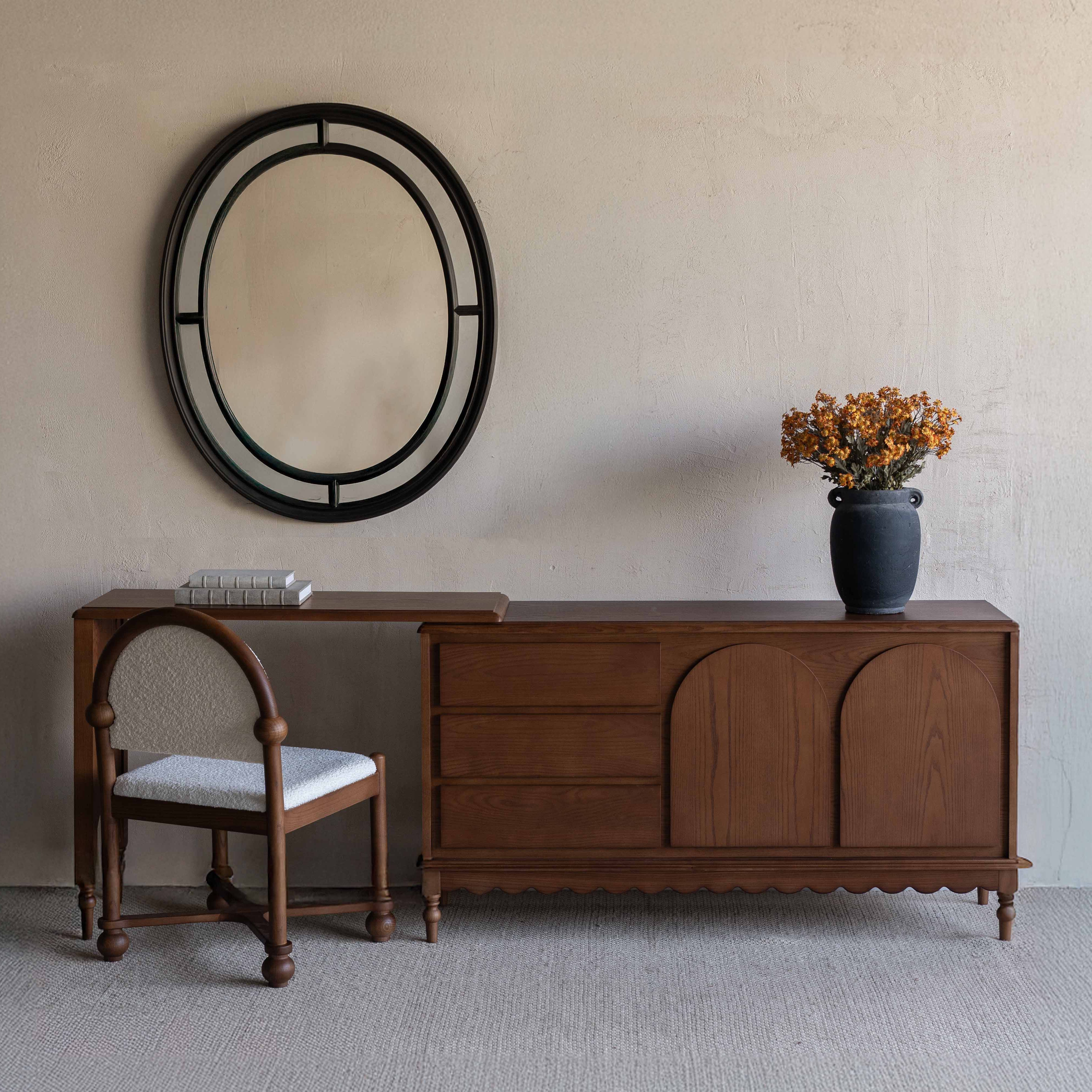 Wooden dresser with chair and decorative mirror in a room setting