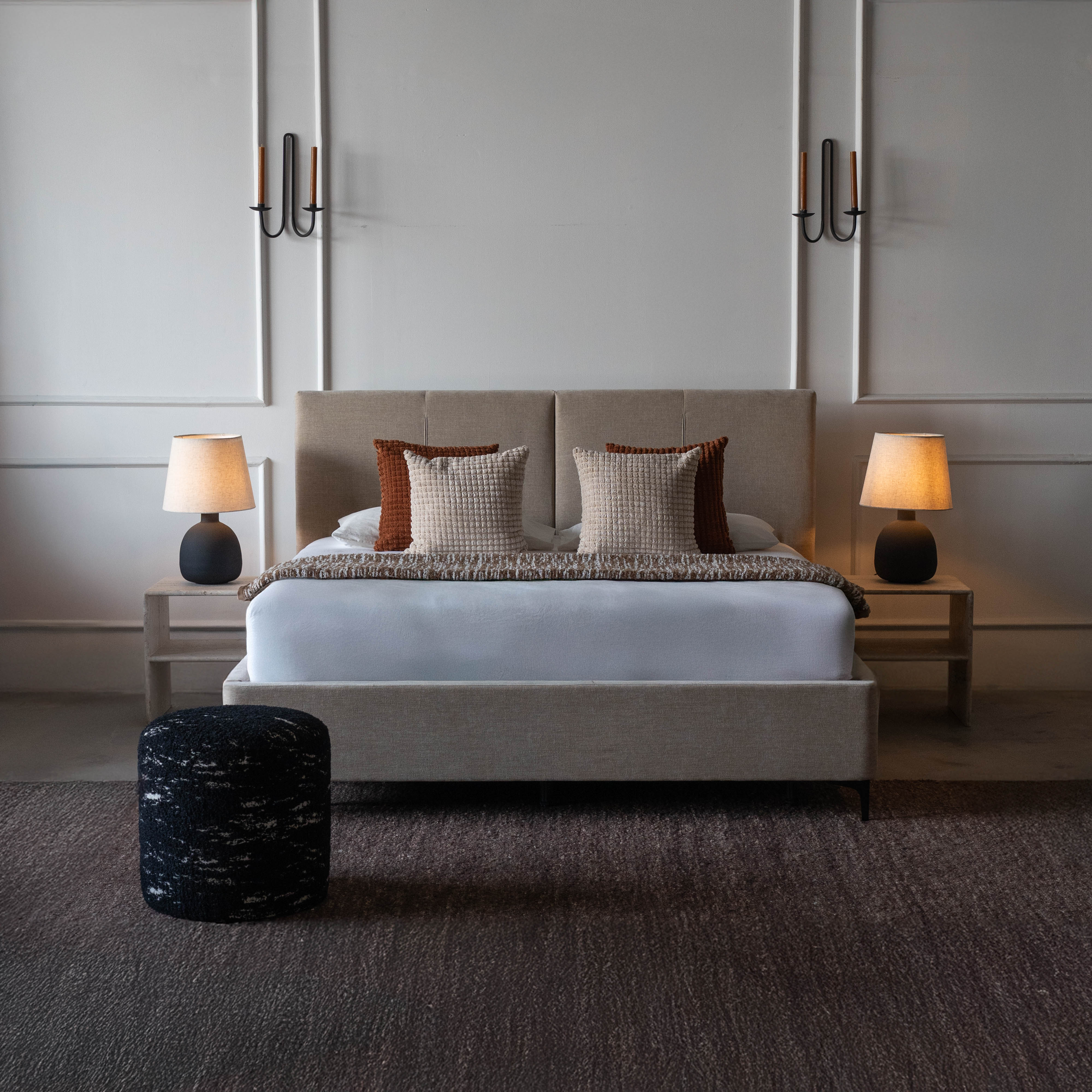Modern bedroom with a bed, nightstands, and lamps.