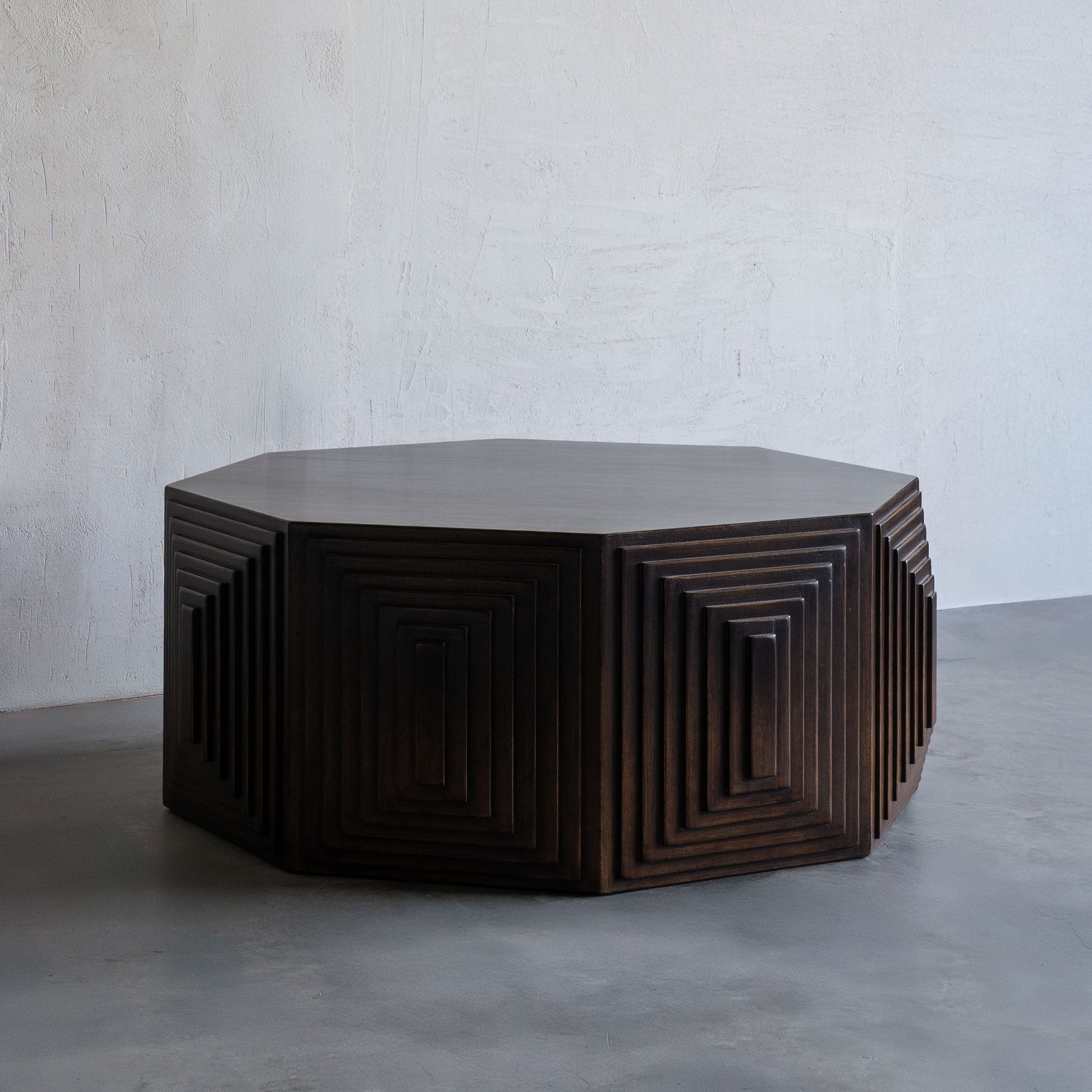 Hexagonal wooden table with geometric design on a plain background