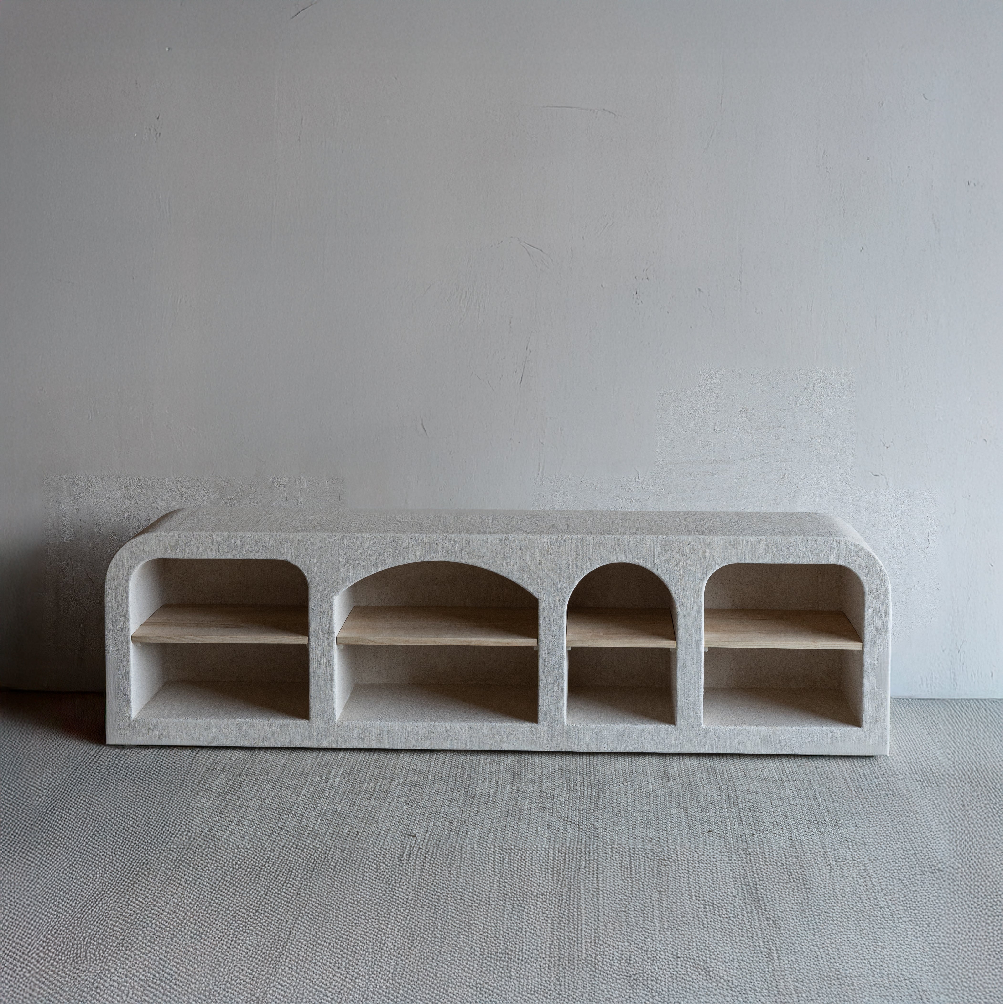 Concrete shelf with arched design on a plain background