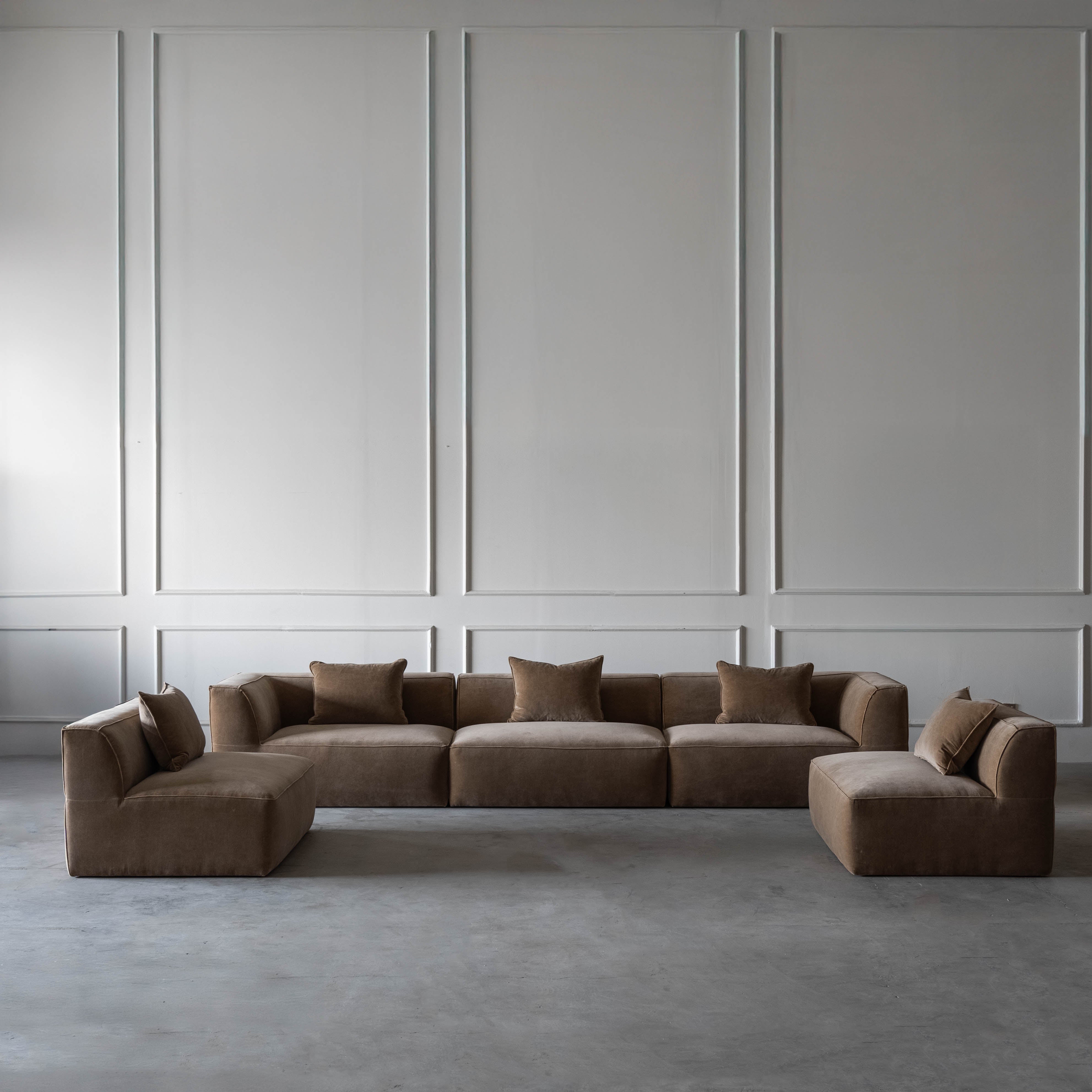Brown sectional sofa in a room with gray walls and floor.